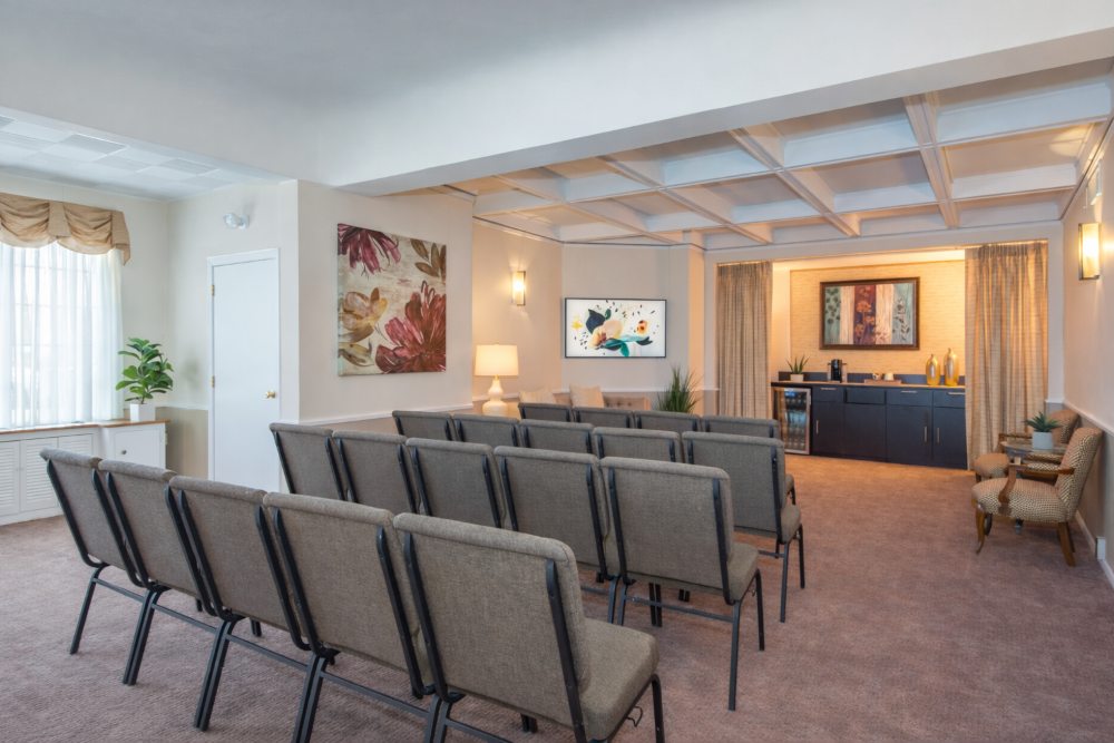 A modern chapel room with neatly arranged seating, warm lighting, and d&eacute;cor at a New Providence, NJ funeral home and cremations.